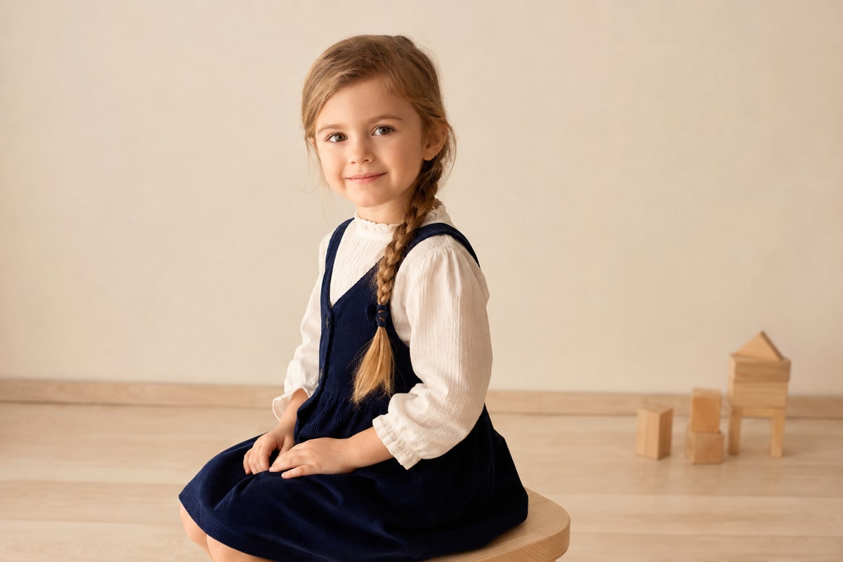 Girl with a braid sitting on a stool – sample portrait from the kindergarten photo ordering gallery